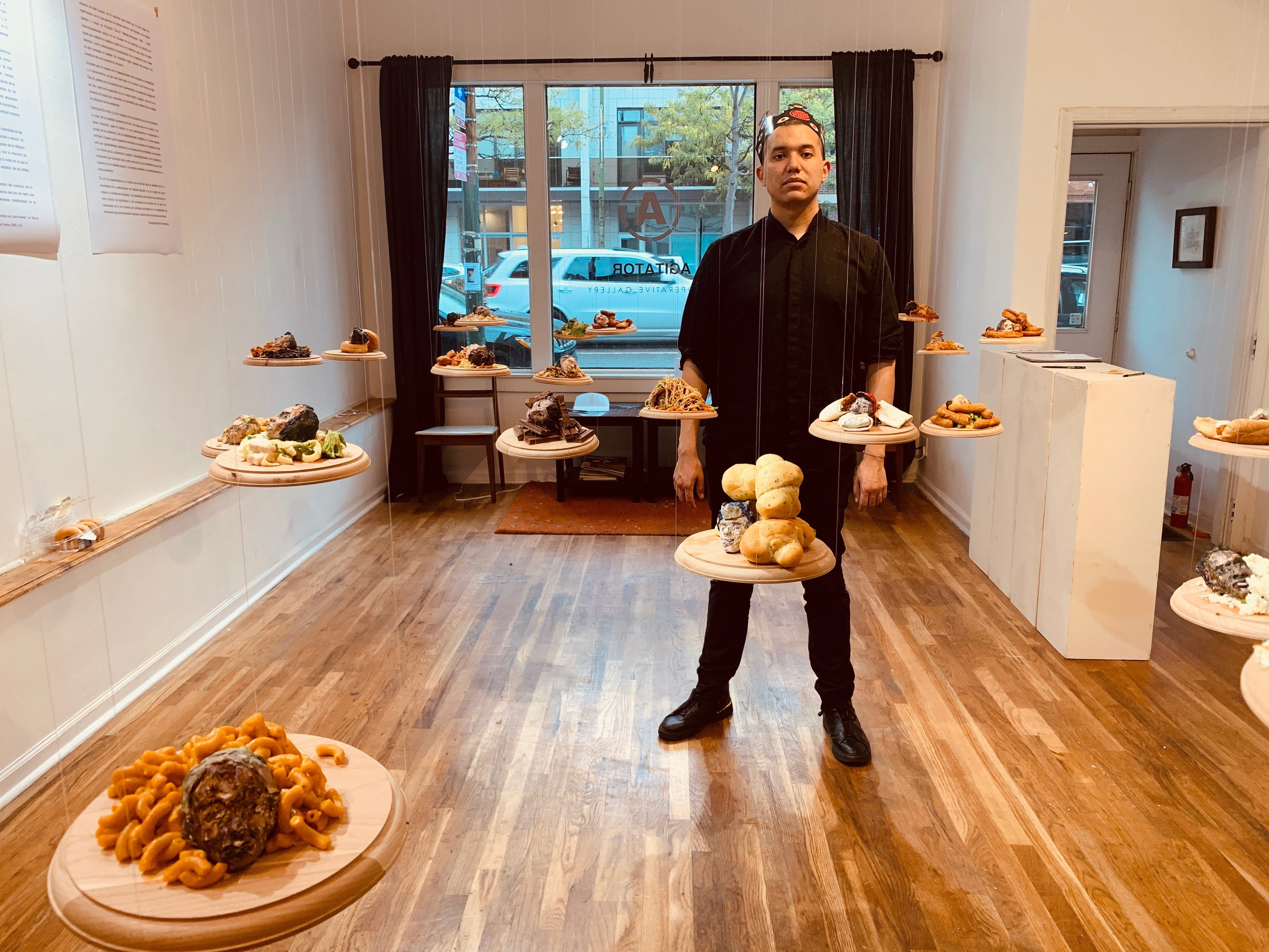 Artist in Agitator Gallery with Floating Art Pieces 