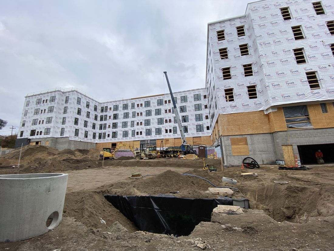 Image of building under constructions there are construction cranes parked in front