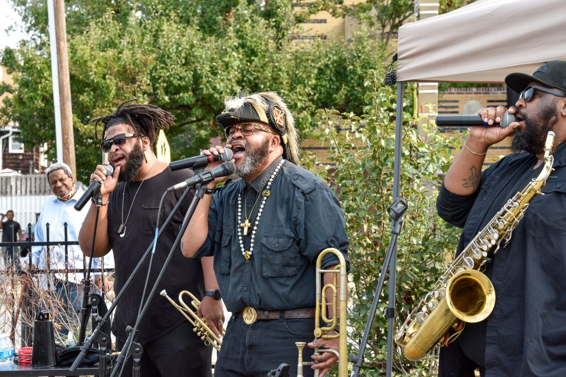 Musicians singing and playing brass instruments.