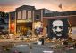The front of the CAFAC building in the evening, in front of the building are flowers, art, flags, and candles to memorialize George Floyd who was wrongfully killed by Derek Chauvin, as proved in a court of law.