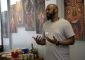 Speaker presenting in front of hanging artwork.