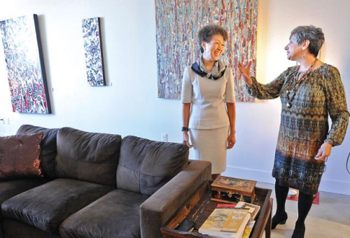 Two people chatting in a gorgeous living room with artworks on the wall.