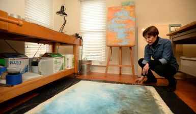 Artist Denise Sagan looks at her artwork
