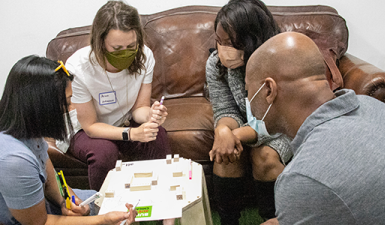 Immersion cohort participants engaged in an activity around a table