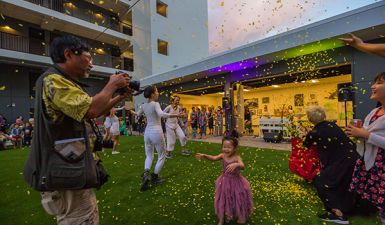 child celebrating in the sunshine being showered by flower petals