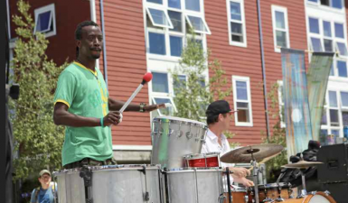 Musicians playing drums outside.